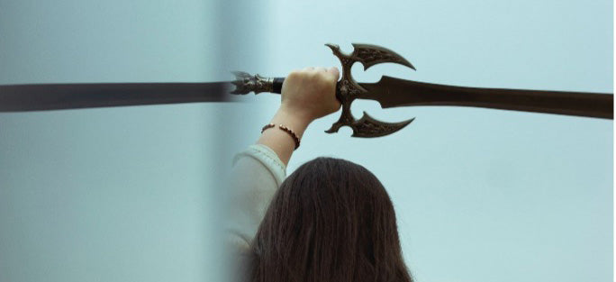 A Viking stands facing away from the camera with a Norse sword raised in the air, ready to go to battle 