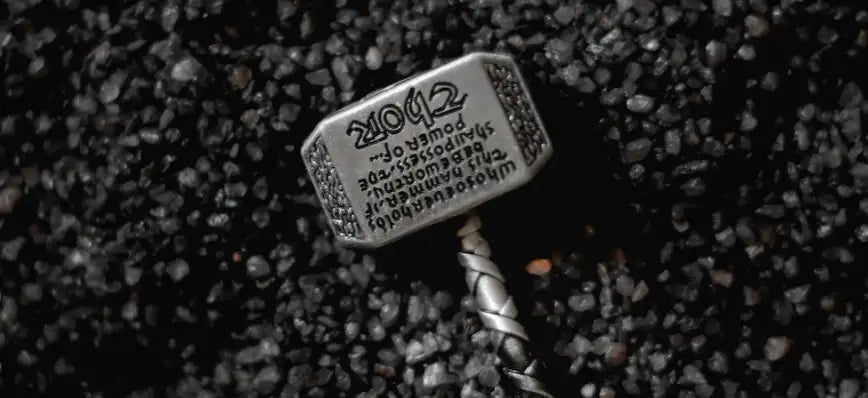 A Mjolnir pendant style hammer on a gravel surface 