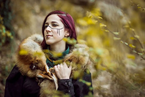 Viking gifts for her. A viking woman stands amongst a field of yellow flowers, looking to the side